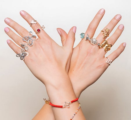imagen de manos de mujer con anillos en colores plateados y plateados , TANYA MOSS