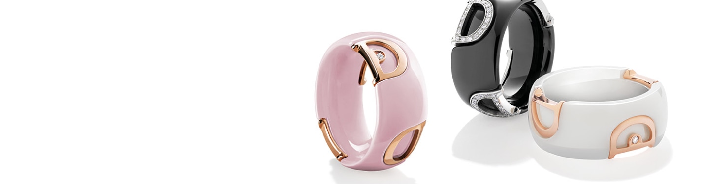 Imagen de tres anillos de la marca DAMIANI, unos color rosa otro negro y el ultimo blanco, con partes de oro de 18 kilates. DAMIANI