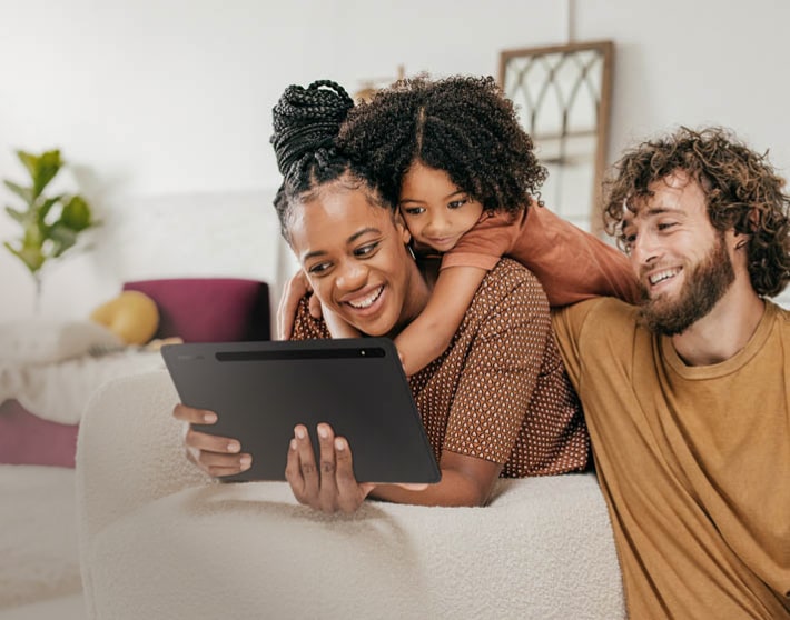 Imagen de una familia viendo una tablet de color negro de la marca samsung