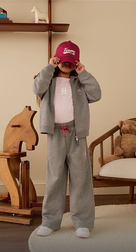 Imagen de niña con pan gris y gorra roja de la marca TOMMY HILFIGER