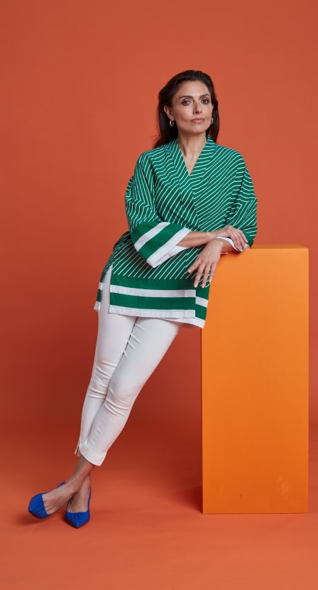 imagen mujer con blusa verde y pantalon blanco, de la marca PERTEGAZ