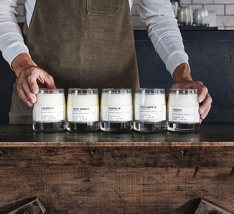 imagen de un hombre frente a una mesa con velas de la marca LE LABO