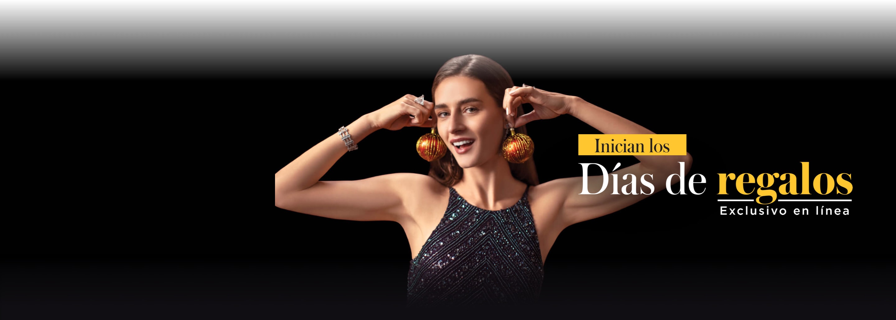 Mujer usando un vestido de noche negro con brillantes. Sostiene un par de esferas navideñas de color rojo junto a sus orejas, como si fueran un par de aretes. Gourmet