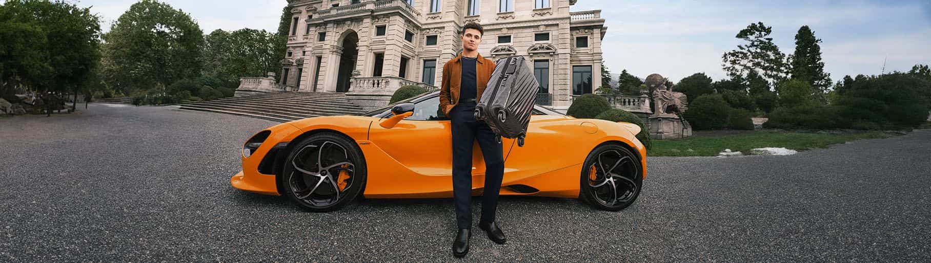 Hombre con carro naranja y mochila gris TUMI
