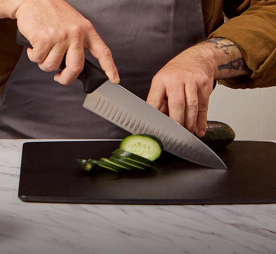 imagen de una tabla de picar en la cual hay un corte de carne y 6 cuchillos con mango rojo, victorinox
