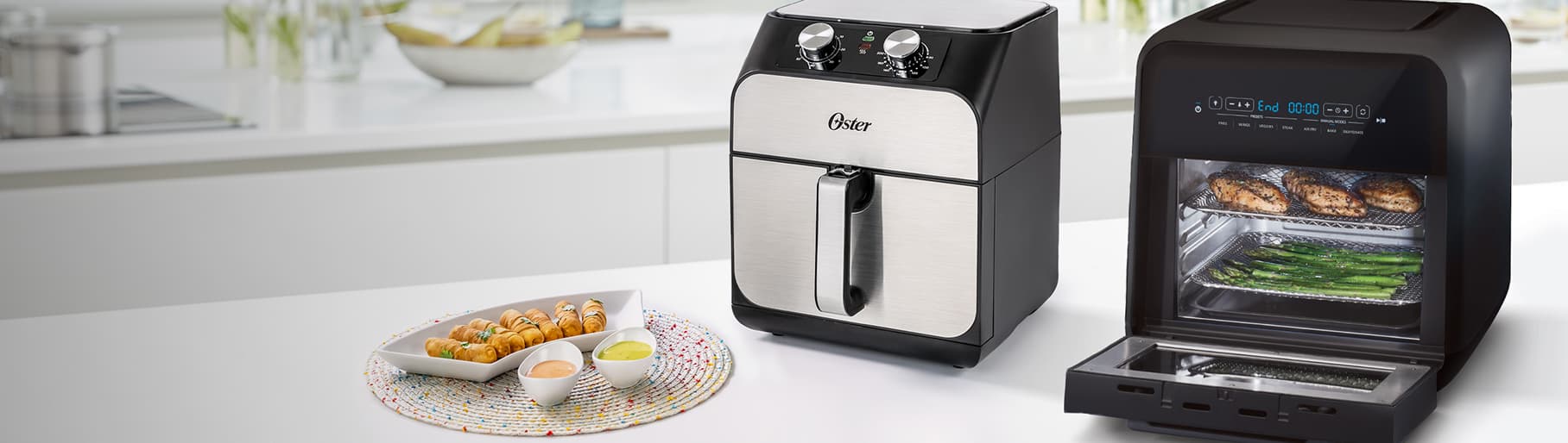 Imagen de una cocina en la cula se encuantra una barra, en la barra se encuantra una freidora electrica de la marca OSTER color negra con plateado y un horno electrico de la marca OSTER de color negro. OSTER