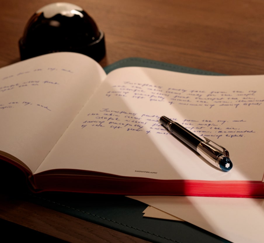 Imagen de boligrafo negro con plateado sobre cuadernos blanco, MONTBLANC