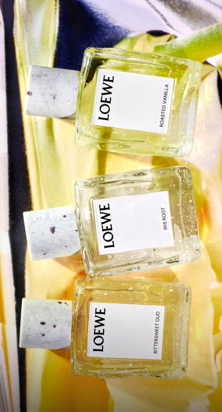 Imagen de mujer junto a botella de locion de la marca LOEWE