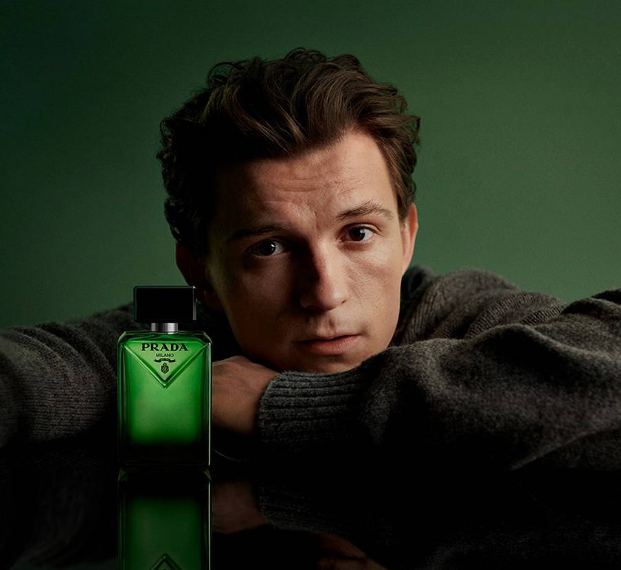 imagen de Tom Holland junto a locion verde de la marca PRADA