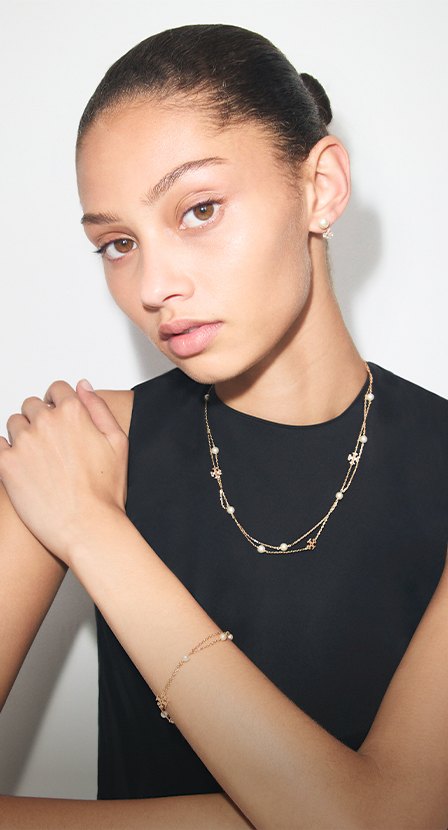imagen de mujer con blusa negra y collar dorado