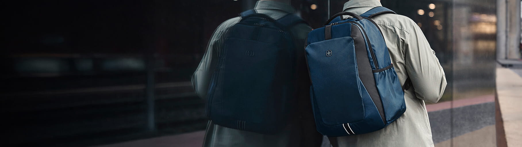 imagen de un hombre de espaldas, lleva una mochila color azul de la marca WENGER 