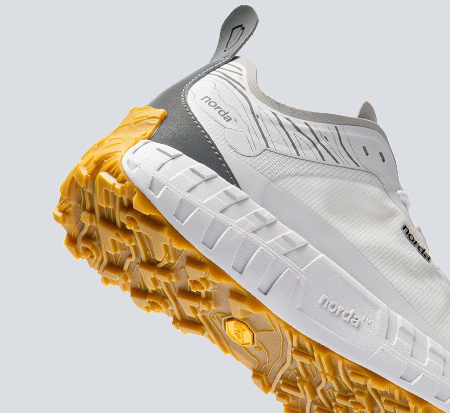 imagen de  tenis blanco con amarillo de la marca NORDA