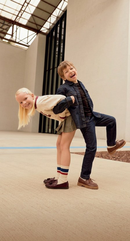 imagen de de niña y niño juegando ella cargando a el en su espalda con ropa de la marca IDO