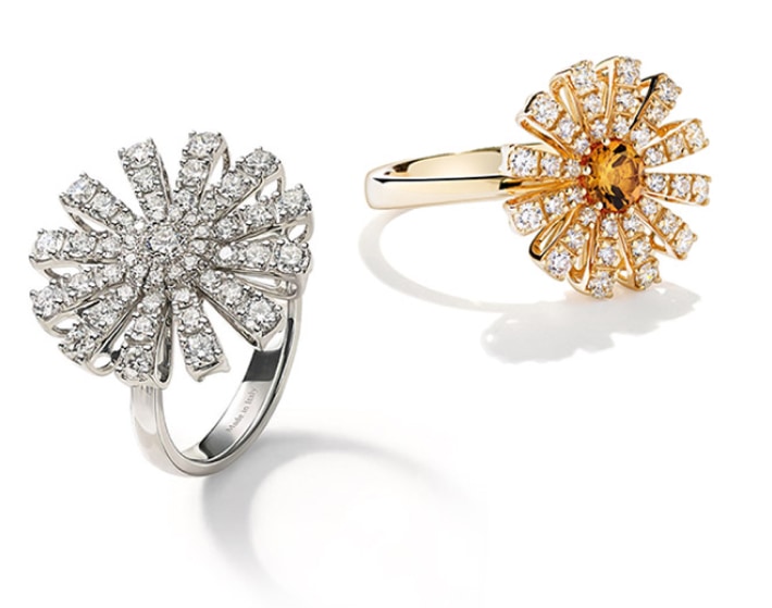 Imagen de dos anillos de la marca DAMIANI, uno color dorado y otro plateado con fomade flor y en los petalos diamantes. DAMIANI