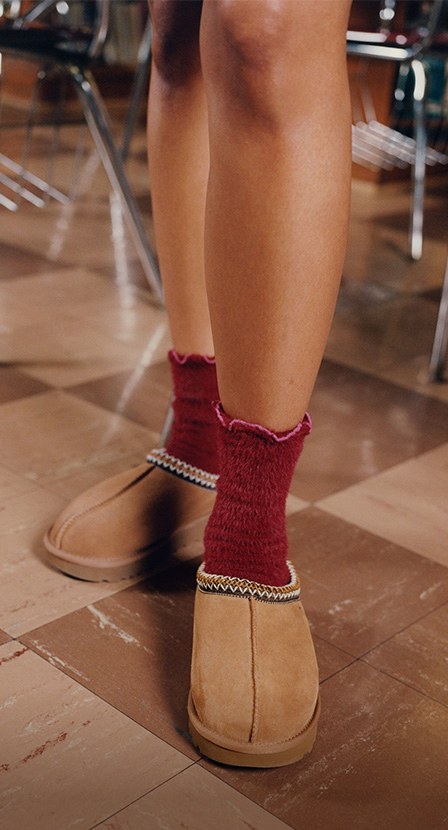 Imagen de mujer con pantunflas cafes de la marca UGG