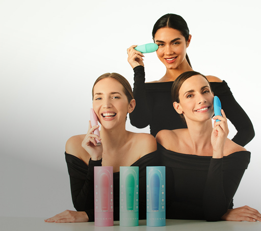 Imagen de tres mujeres con blusa negra, cada una usa un producto de la marca UNICSKIN, para masajear el rostro. UNICSKIN