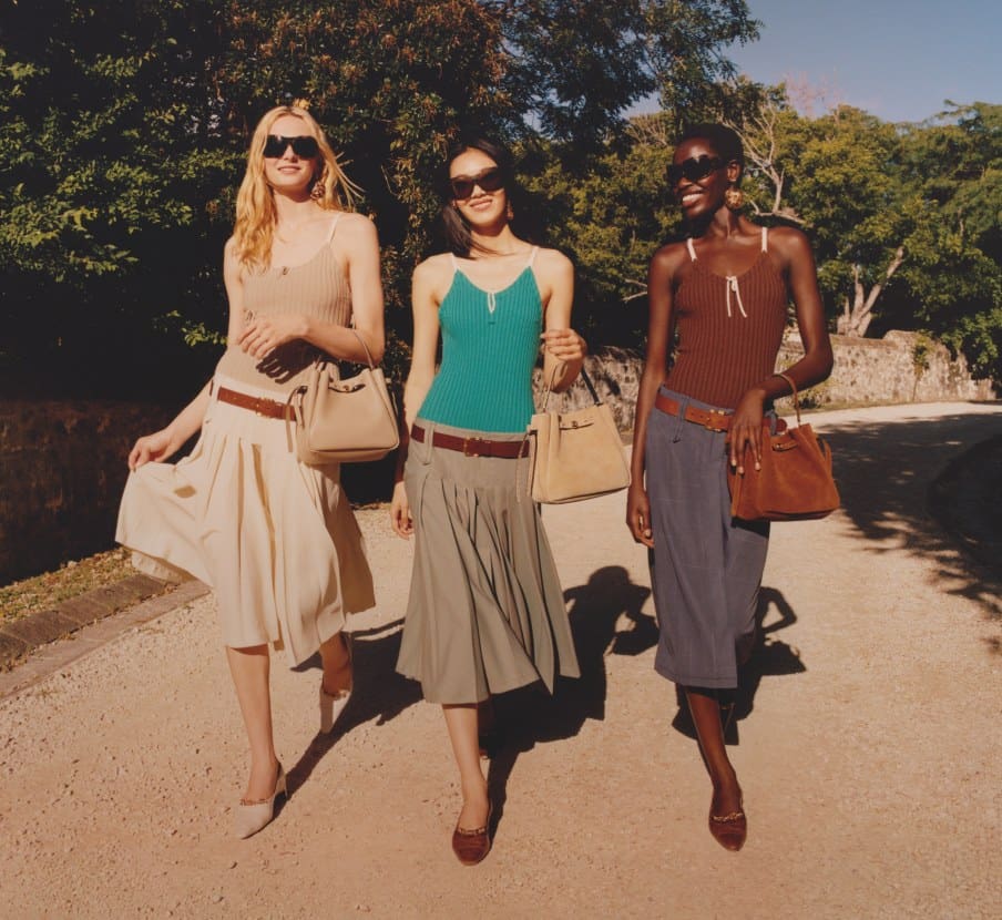Imagen de tres mujeres con productos de la marca TORY BURCH