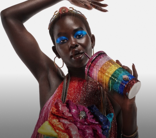 Imagen de una mujer con un vazo y ropa de colores LGBT. Pride