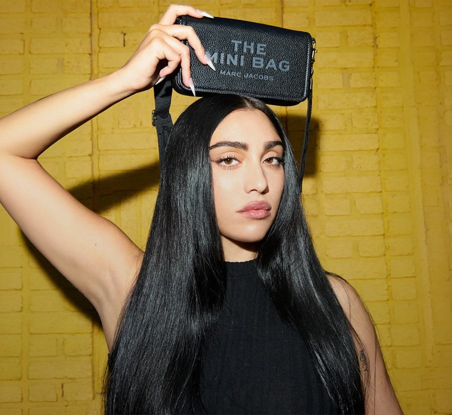 imagen de mujer con bilso negro y vestido negro de la marca MARC JACOBS