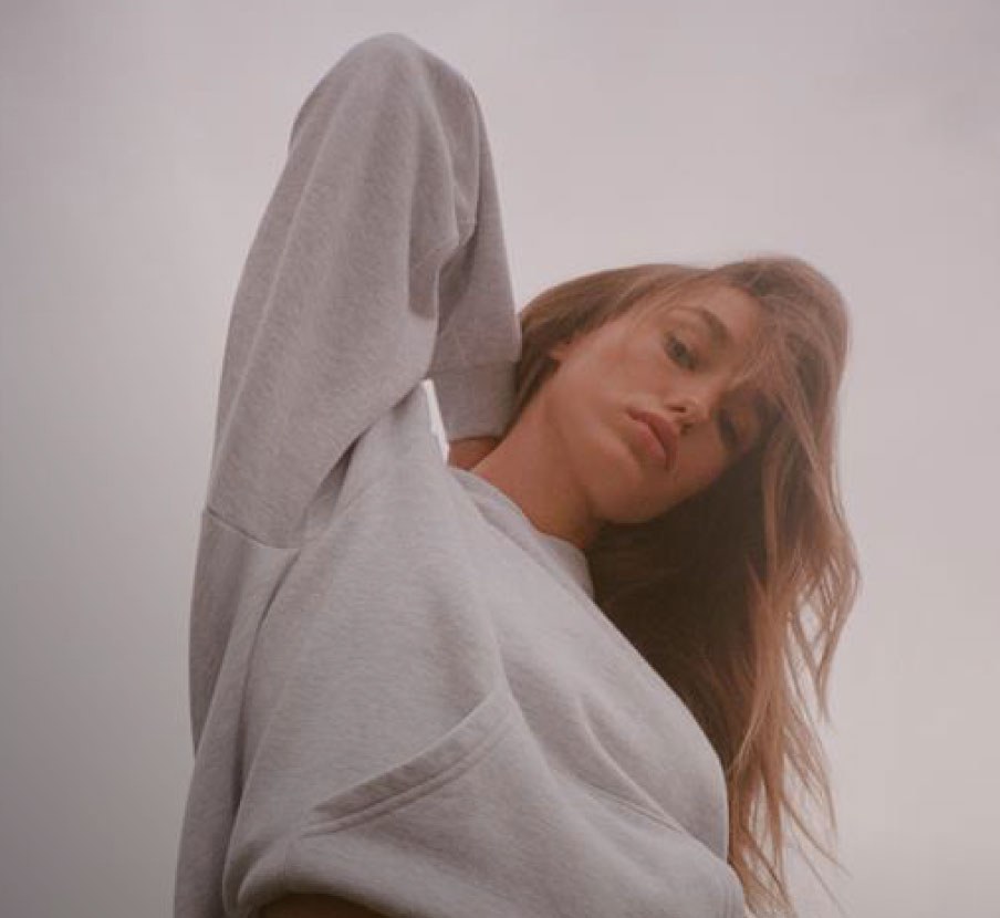 imagen de mujer con sudadera gris de la marca SKIMS