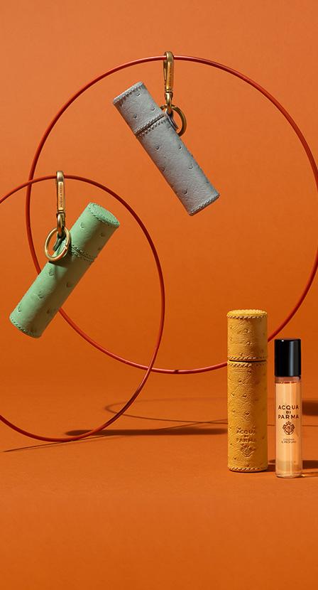 Imagen de una 5 desodorentes de colores diferentes en un fondo de color naranja. ACQUA DI PARMA