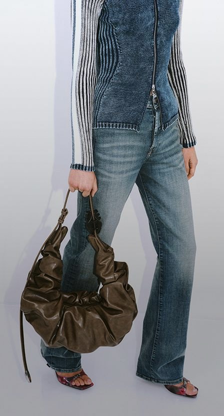 Imagen de mujer con ropa de mezclilla y bolso cafe de la marca diesel