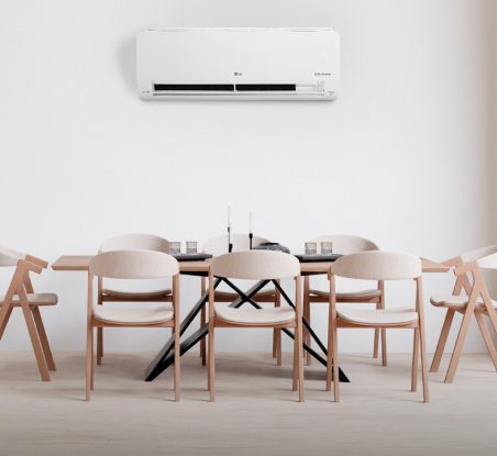 imagen de comedor con mesa y sillas color cafe sobre llas un aire acondicionado blanco LG aire acondicionado