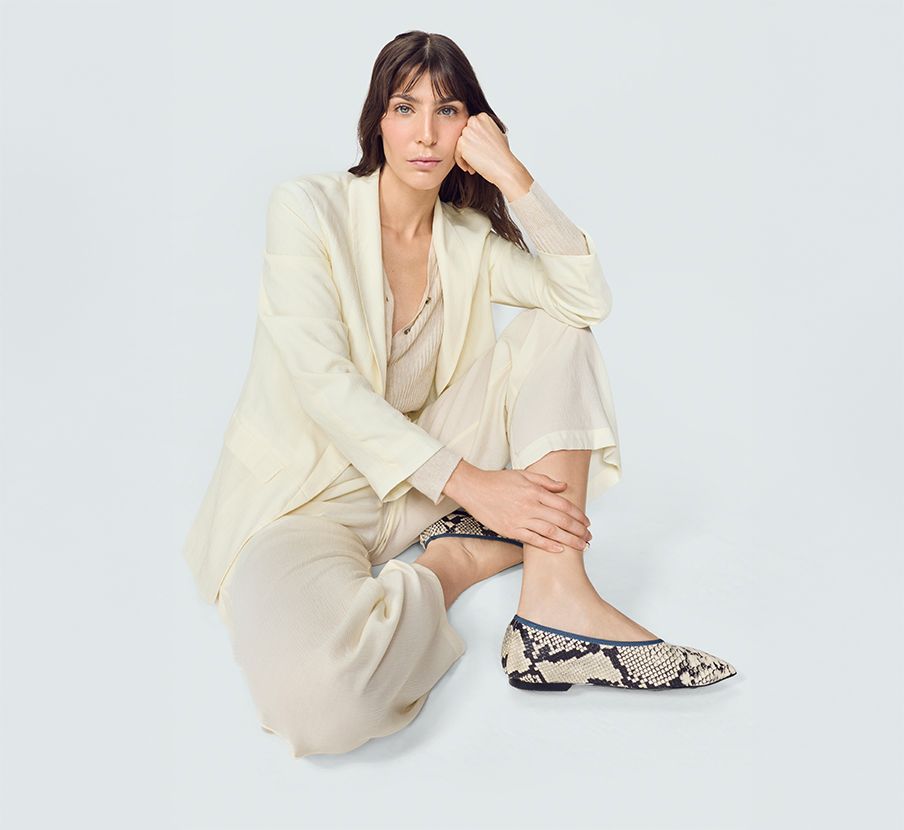 imagen de una mujer usando conjunto de blusa, pantalon y saco de color hueso de la marca EPSILON