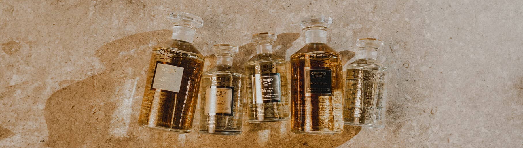 imagen de 5 botellas de perfime de color dorado