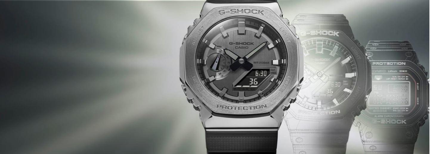 Imagen de un reloj G-SHOCK de la marca CASIO color gris, desvanecidos atrás de el dos modelos antiguos del mismo modelo. Relojes Hombre Moda