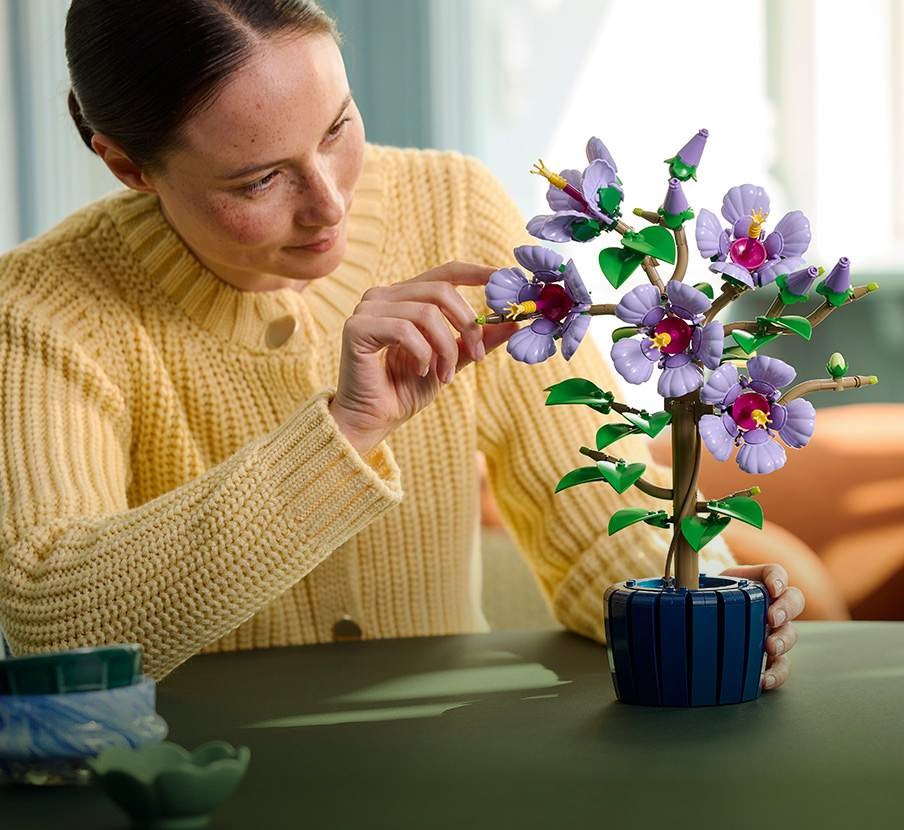 imagen de mujer armando flores de la marca LEGO
