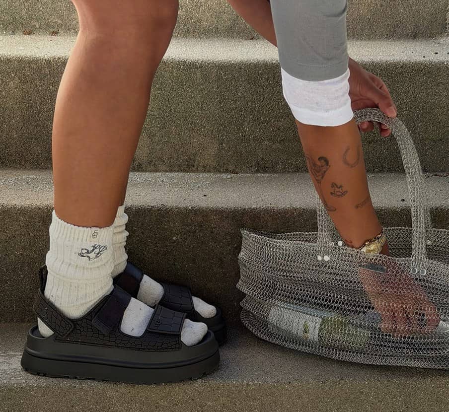 imagen de mujer con sandalias negras de la marca UGG