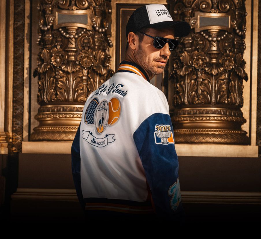 Imagen de hombre con chamarra blanca copn azul de la marca LE-COQ-SPORTIF