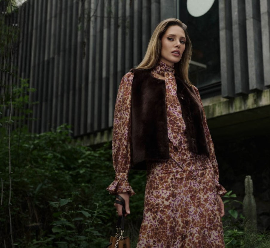 imagen de mujer con vestido rojo con blanco y chaleco cafe de la marca DHIERRO