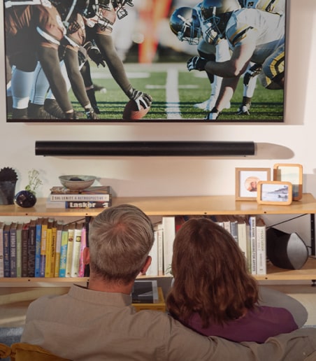 imagen de pareja viendo juego de futbol americano en pantalla plana SONOS