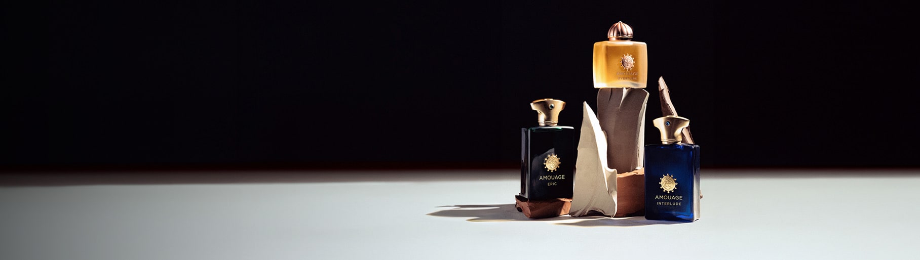 imagen de tres botellas de lociones de la marca AMOUAGE