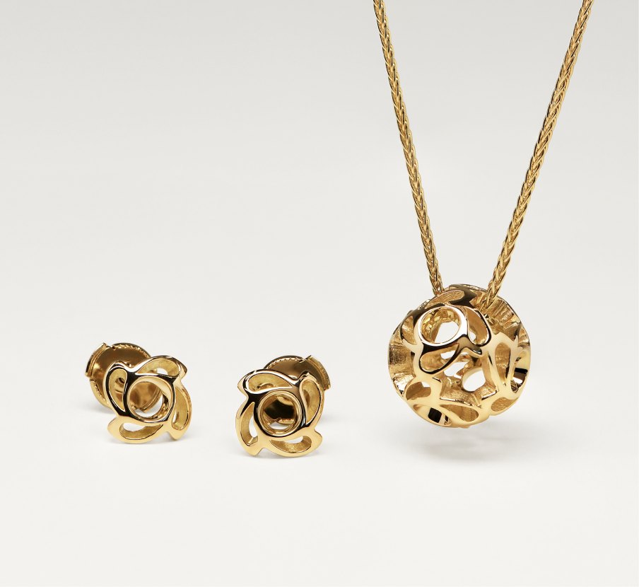 imagen de dije y aretes dorados de la marca TANE
