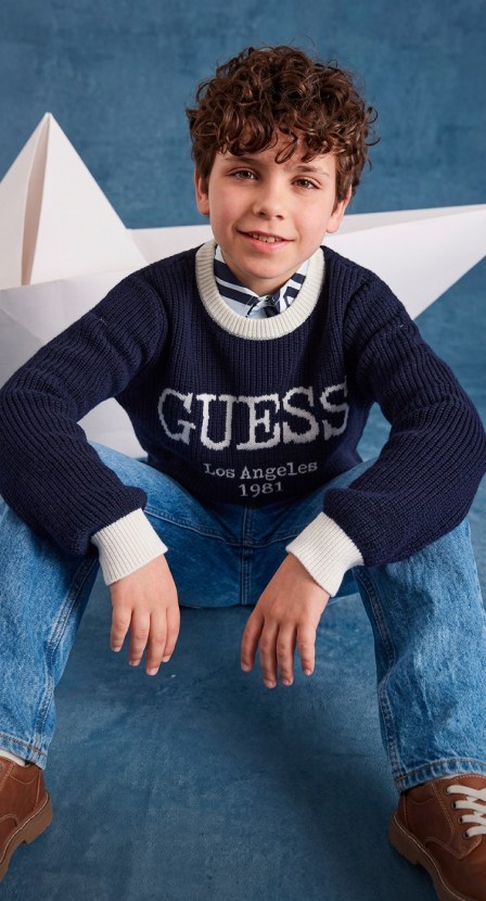 niño con playera negra y pantalon de mezclilla azul 