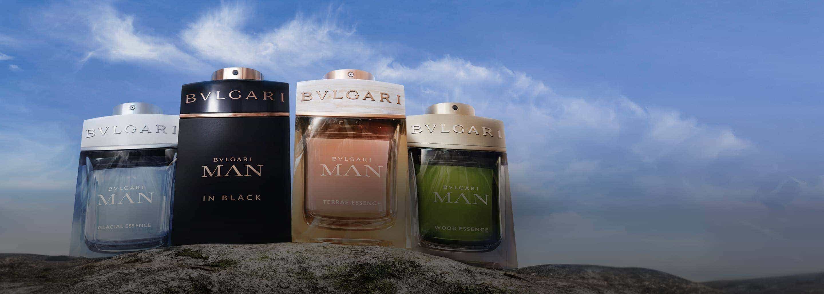 Imagen de cuatro frascos de perfume de la marca BVLGARI de distintas presentaciones para hombre, colocados en ilera sobre una piedra, BVLGARI