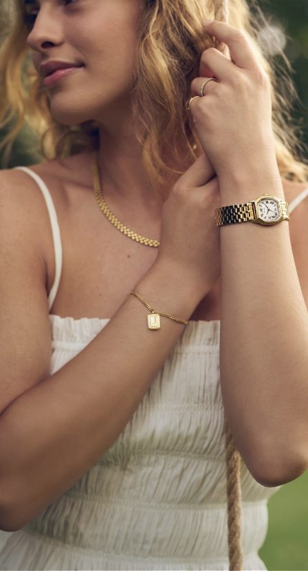 imagen de una mujer con ropa blanca y reloj plateado de la marca FOSSIL