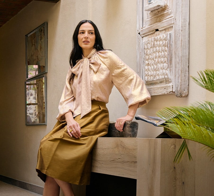 imagen de mujer con falda cafe y blusa beige de la marca PERTEGAZ 