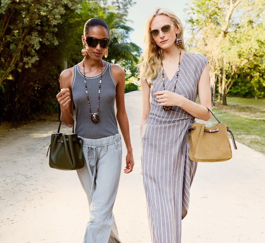 imagen de dos mujeres con bolsos verde y cafe de la marca TORY BURCH