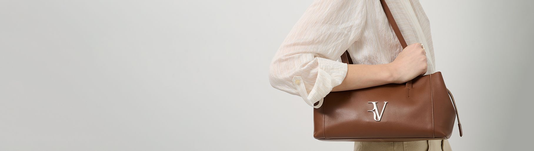 imagen de mujer con bolso cafe de la marca ROBERTOVERINO