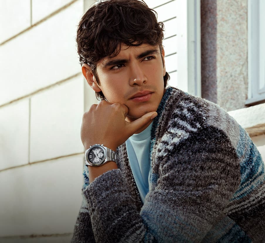 imagen de hombre con sueter de colores y reloj plateado GUESS