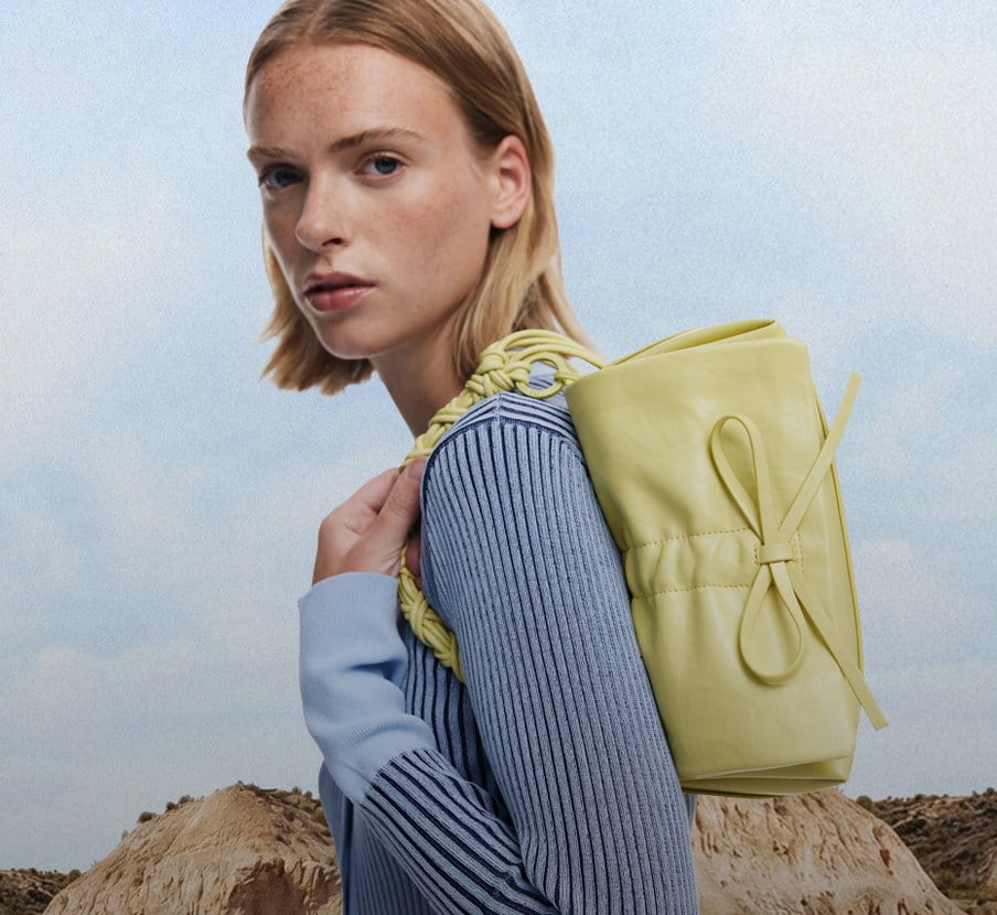 Imagen de mujer con bolso verde de la marca DESIGUAL
