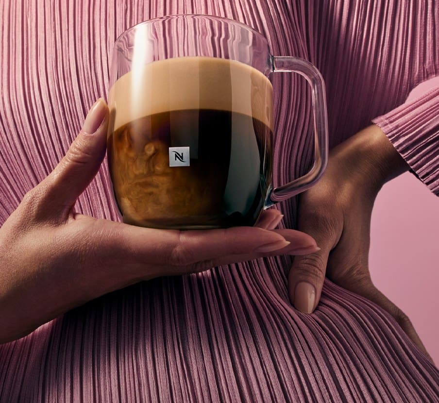 Imagen de una mujer cargando una taza de cafe, NESPRESSO