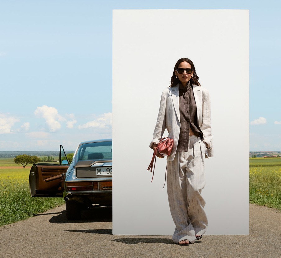imagen de mujer caminando con traje blanco de la marca ADOLFO DOMÍNGUEZ