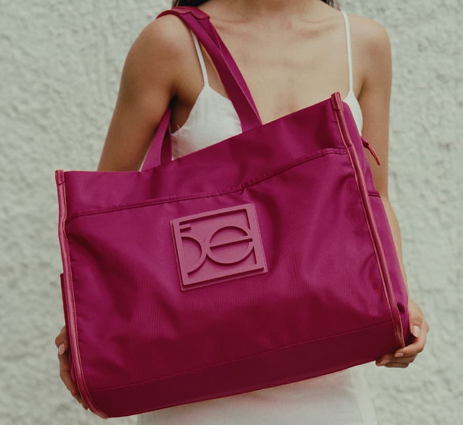 Mujer usando pañalera grande TOTE color rosa de la marca CLŌE