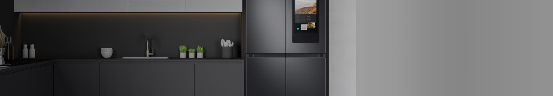 Imagen un refrigerador gris empotrado, al lado una pared blanca y una cocina gris
