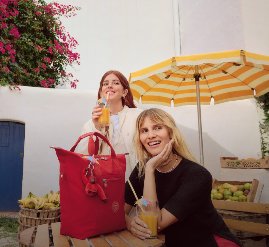 imagen de dos mujeres junto a bolso rojo de la marca KIPLING